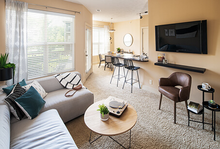 The living room and dining area of a River Park Apartment